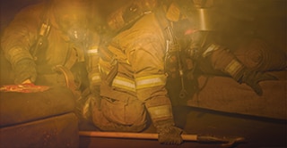 Firefighters crawling through a smoke-filled building