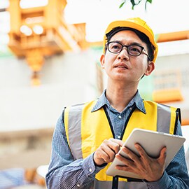A crew member uses a tablet in the field to access the roadway asset management system.