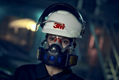 Trabajador con casco, gafas y respirador 3M.
