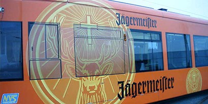 Side of a tram wrapped in a vibrant orange and yellow 
