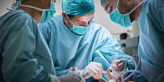 Three Surgeons operating patient for breast implant
