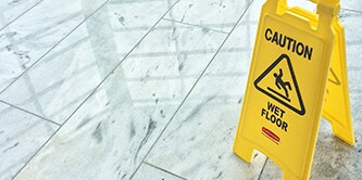 Imagen de un cartel amarillo con un mensaje alertando que el piso esta mojado.
