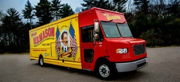 Imagen de una camioneta roja y amarilla ploteada con bandreas de EEUU
