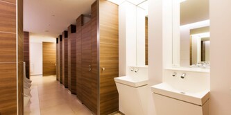 Imagen de un baño suite luminoso. Con doble lavabo, paredes de madera artificial marrón.
