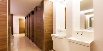Imagen de un baño suite luminoso. Con doble lavabo, paredes de madera artificial marrón.
