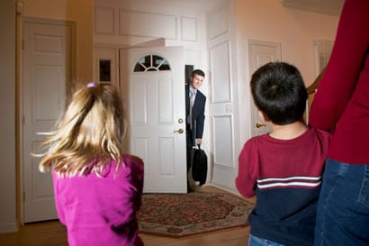 Children greeting their father at the door.