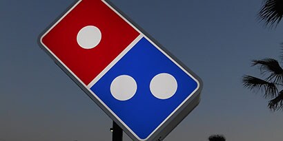 Imagen de un cartel luminoso con forma de dominó azul, blanco y rojo
