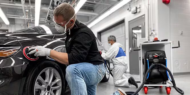 Imagen que muestra a un hombre usando abrasivos de primera calidad con herramientas de primera calidad en un automóvil para lograr resultados excelentes.
