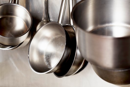 Una cocina con ollas y sartenes desde el techo.
