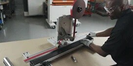 Un hombre con equipo de seguridad utiliza el Laminador de Línea Recta 3M™.
