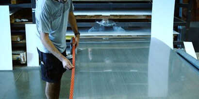 Image of a person applying VHB tape to a large panel.
