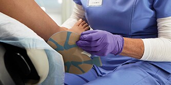Wound care clinical applying 3M™ Tegaderm™ Dressing to patient wound
