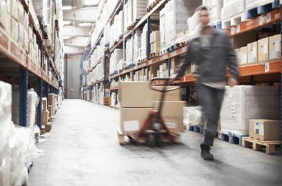 Work man running through warehouse.