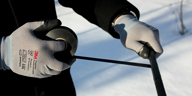 Un trabajador envolviendo un cable eléctrico con la cinta aislante 3M Super 33+.
