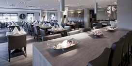 Un restaurante moderno con las mesas organizadas.
