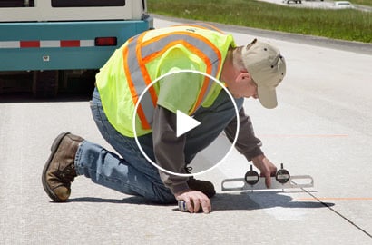 Workman measuring on road.