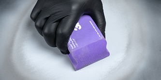 Técnico realizando pasos de esfuminado, aplicación de primer y relleno para lijado en reparación de carrocerías.
