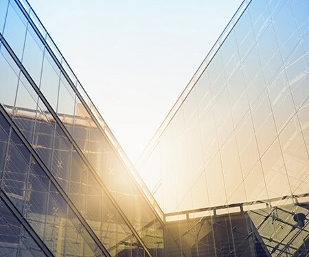 El brillante sol brilla sobre edificios con ventanas angulares.
