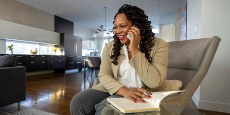 Woman sitting in her living room talking on her mobile phone.
