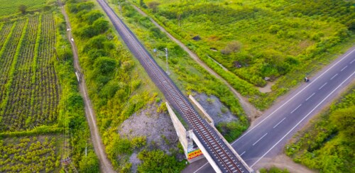 Aerial view of a pedestrian bridge over a two lane road.
