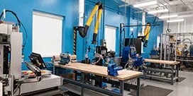 Centro de Procesos de Unión de 3M con dos mesas con máquinas y equipos.
