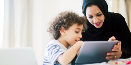 Woman and a child sharing the view on a tablet device.
