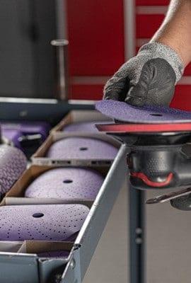 Trabajador utilizando una lijadora con un disco abrasivo 3M.