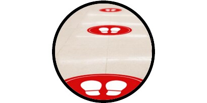 ícono que muestra gráficos de piso rojo con íconos de pies para ayudar con el distanciamiento social en los pisos.

