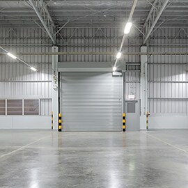 View of loading-bay doors leading to a spacious area with concrete floors.