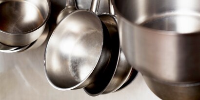Sartenes de aluminio colgadas en una cocina comercial.
