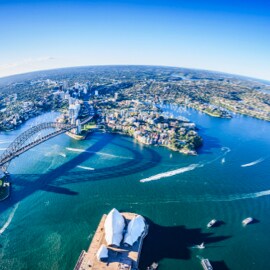 Aerial view of a coastal city with watercraft traffic.